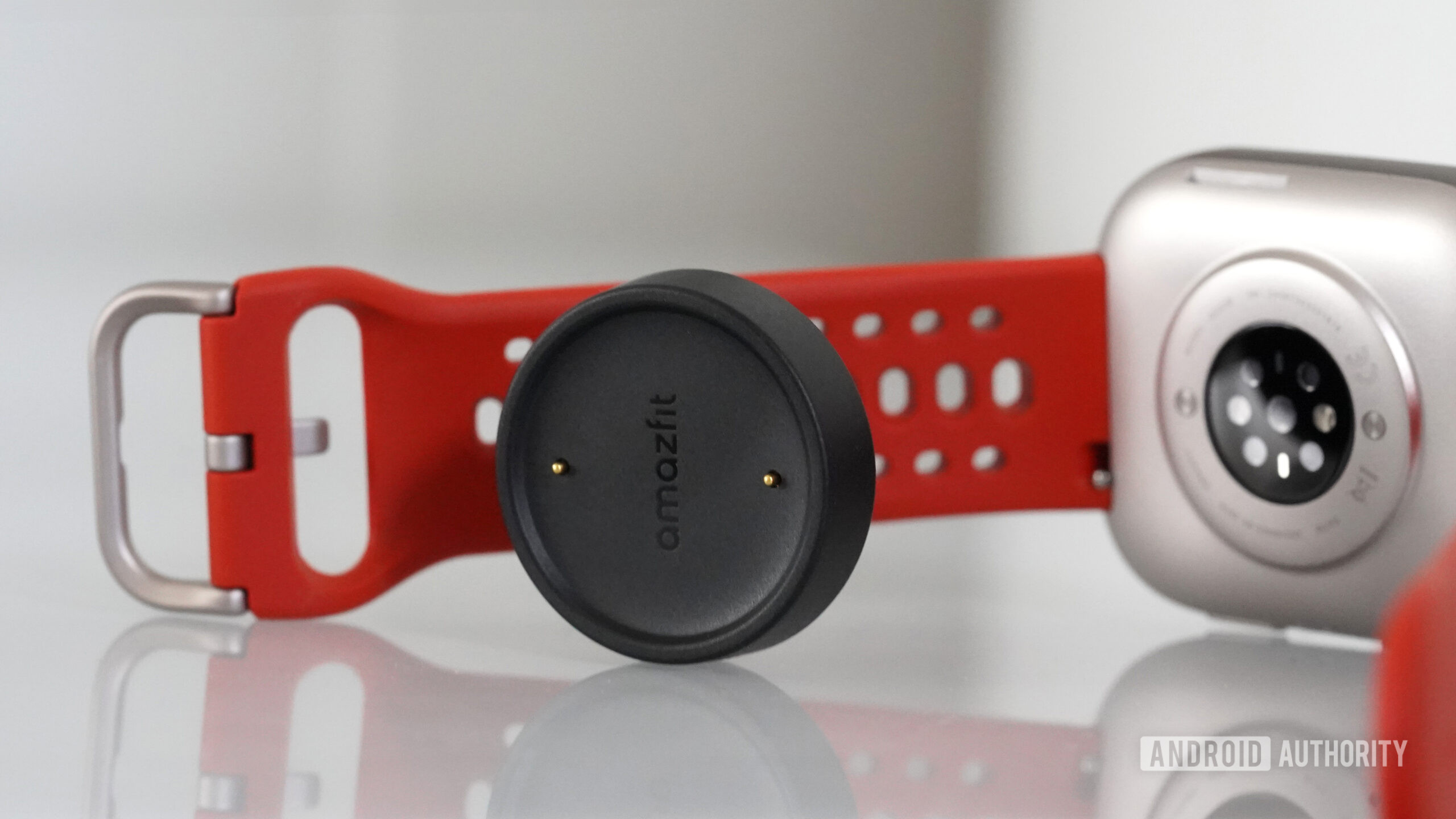 Amazfit Bip 6 Charging Puck An Amazfit Bip 6 rests alongside its charging puck.