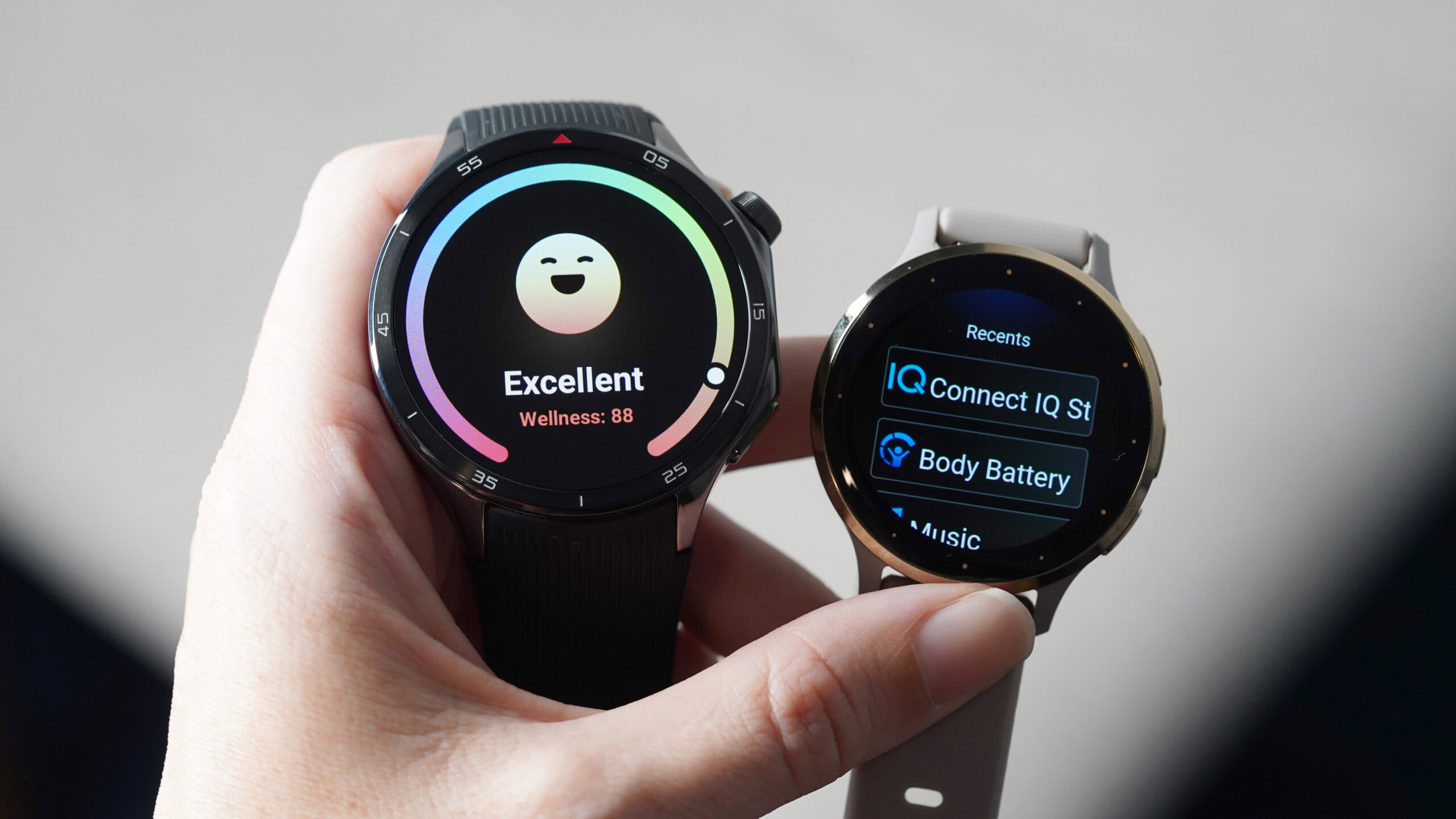 Garmin Venu 3 OnePlus Watch 3 A users holds but a OnePlus Watch 3 and Venu 3 in hand.