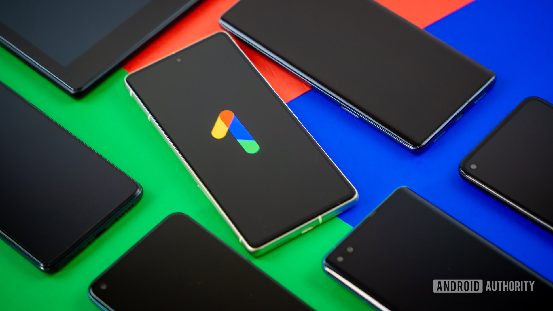 Google One logo on smartphone next to other devices Stock photo 2 Google One logo on smartphone next to other devices Stock photo 2