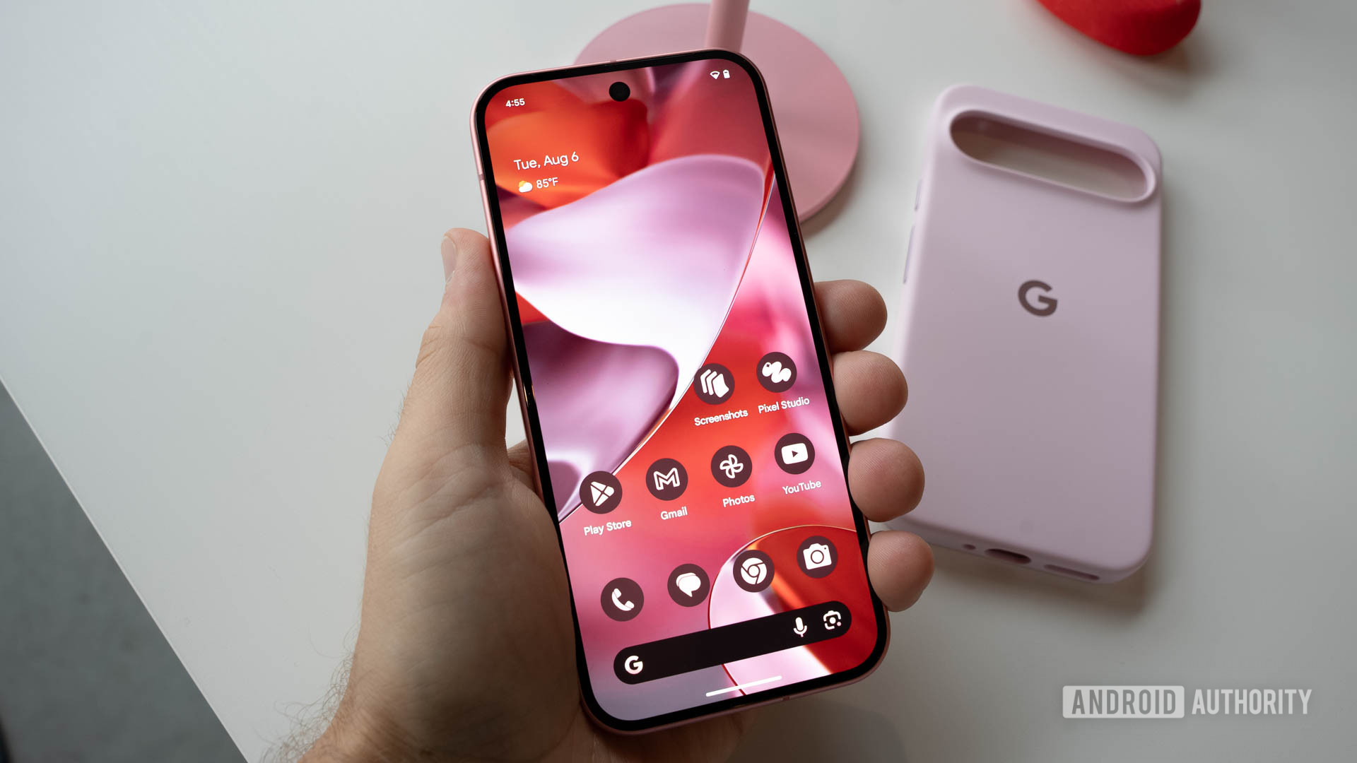 Google Pixel 9 in Peony in person's left hand showing Android 14 home screen Google Pixel 9 in Peony in person's left hand showing Android 14 home screen