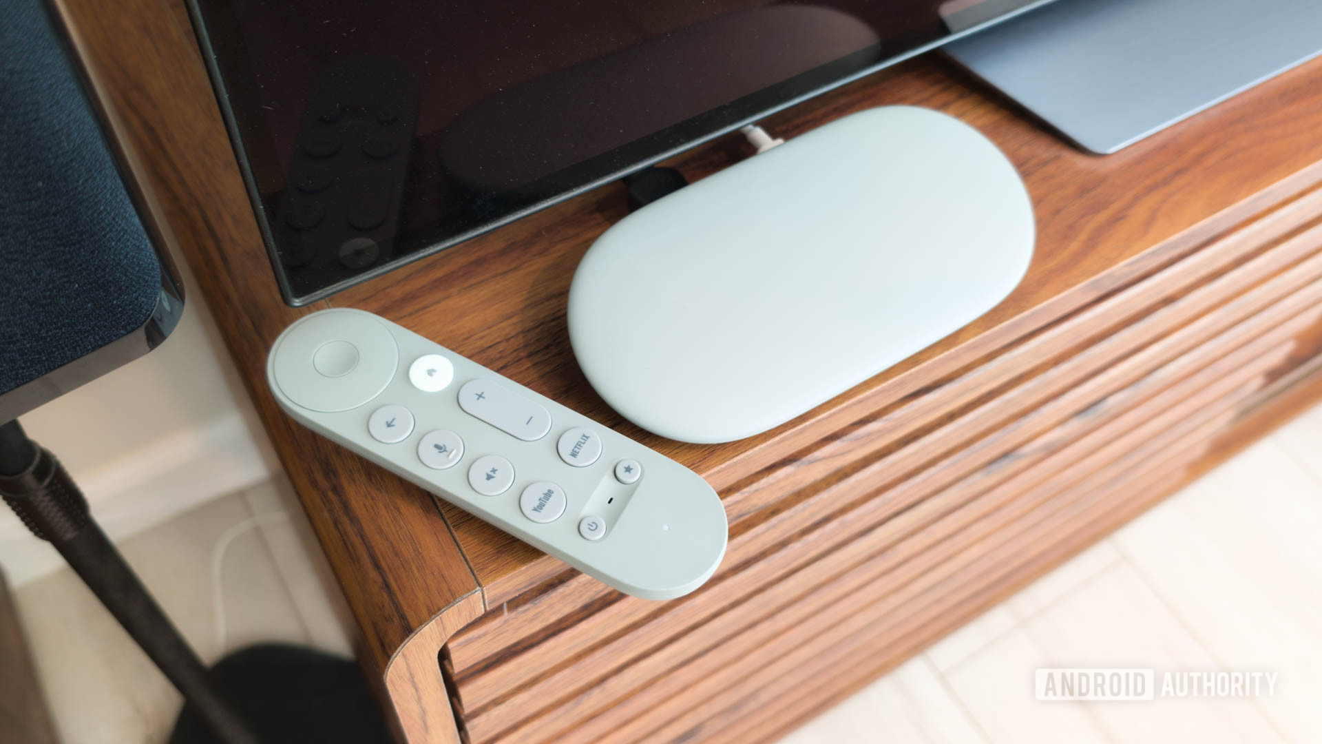Google TV Streamer with remote on TV console hero Google TV Streamer in best smart home list.