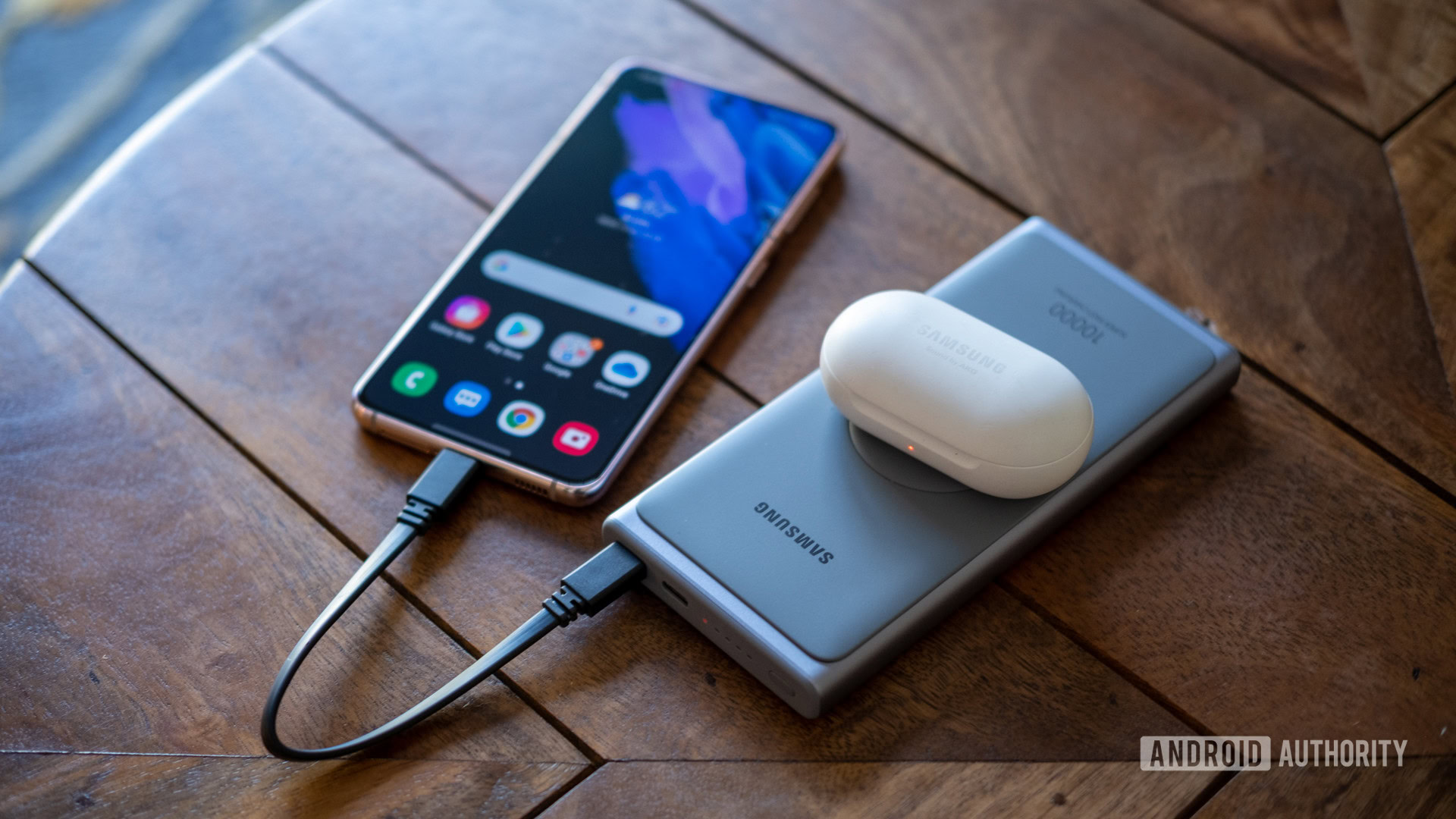 samsung super fast power bank on table charging s21 and galaxy buds above Samsung super fast power bank on table charging S21 and Galaxy Buds above
