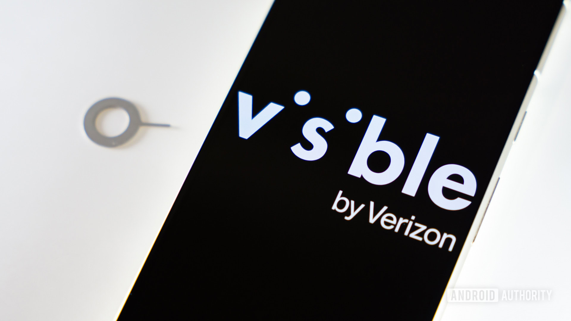 Visible by Verizon logo on smartphone next to SIM ejector tool Visible by Verizon logo on smartphone next to SIM ejector tool